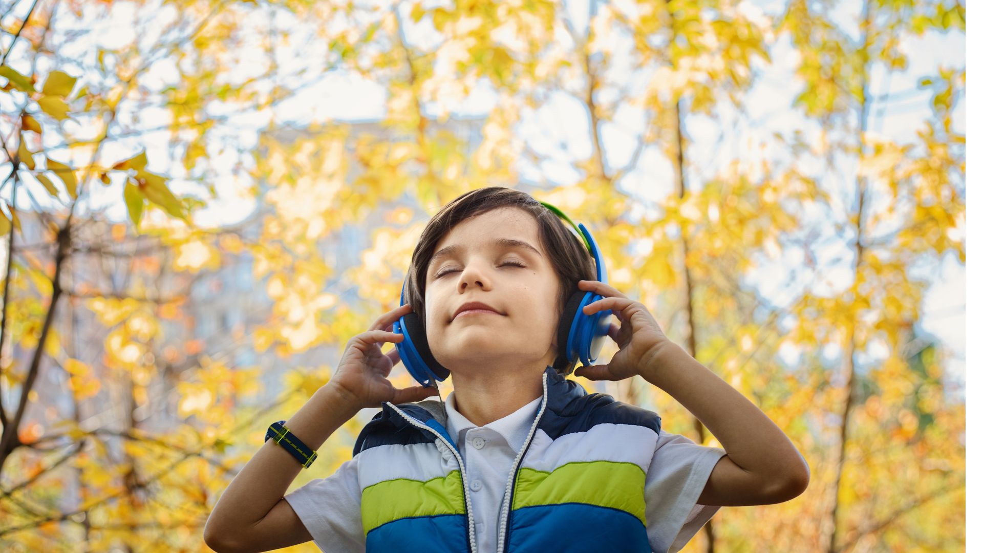 Child in nature listening to music on headphones